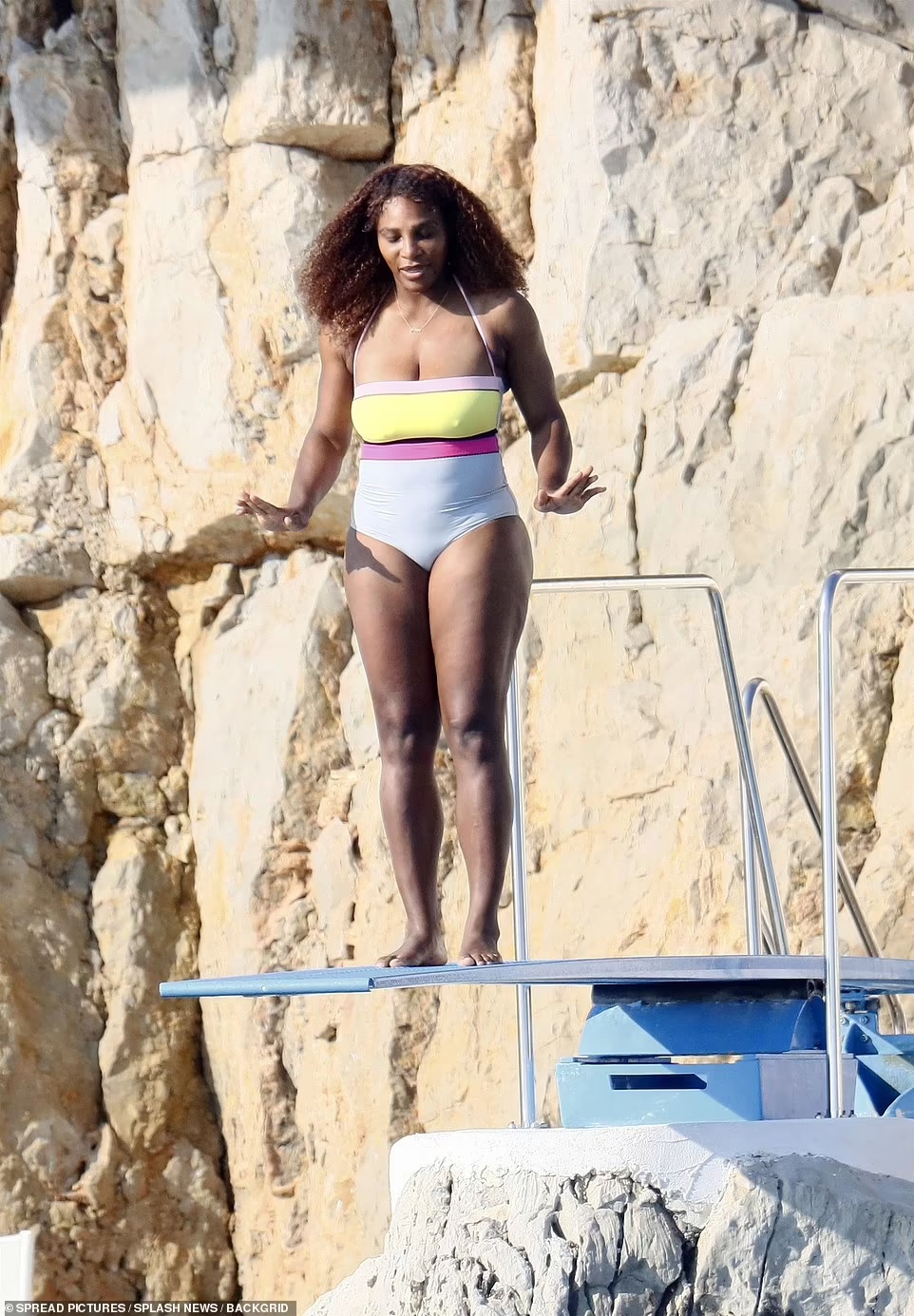 Serena Williams perched on the end of the blue diving board and put out her arms for some balance before jumping off